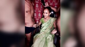 Dos hombres se turnan para acariciar a una chica con un sari verde y lencería negra 1 mín. 50 sec